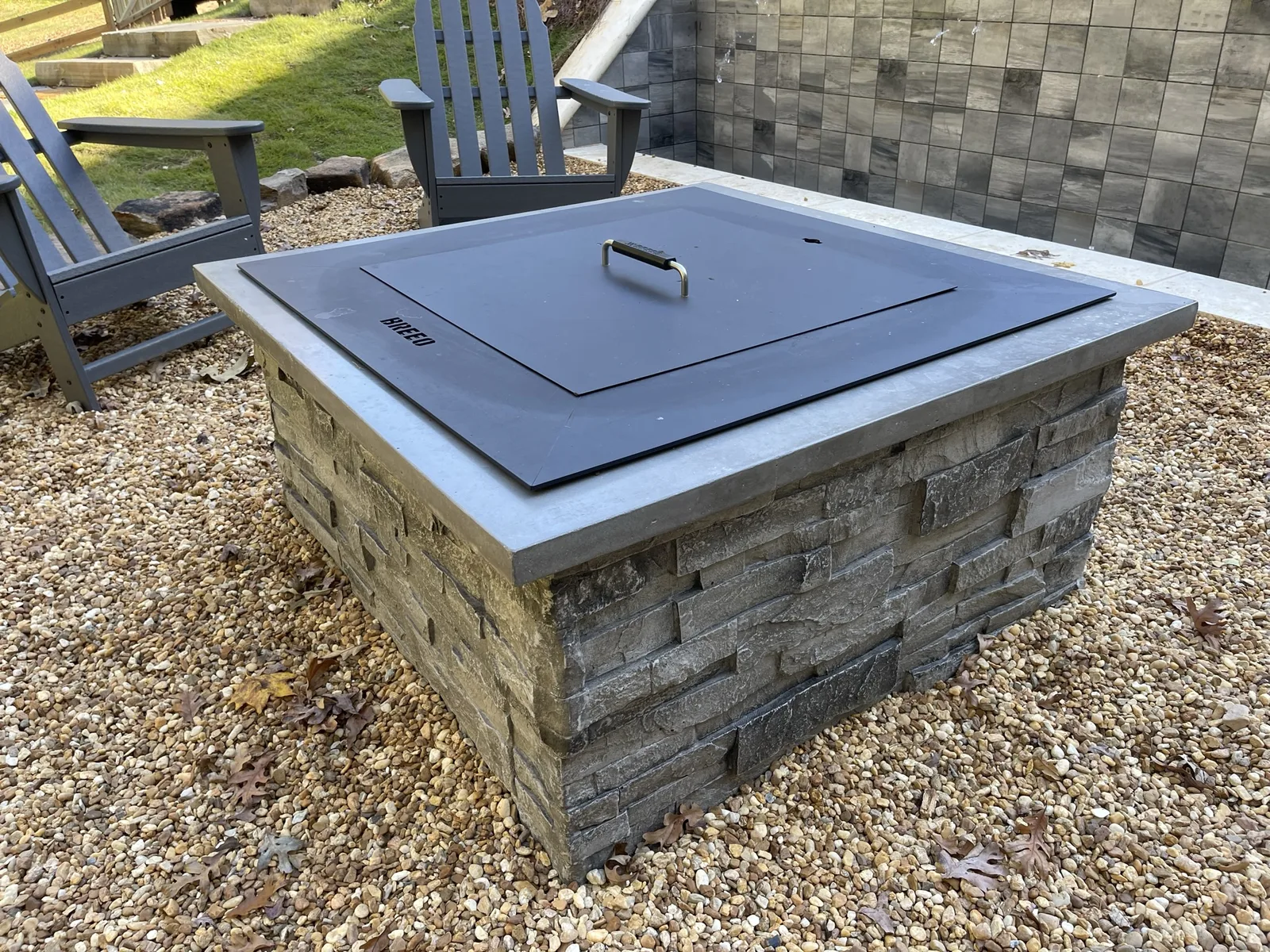 RutherfordMade stone fire pit detail at dusk in a finished outdoor living space