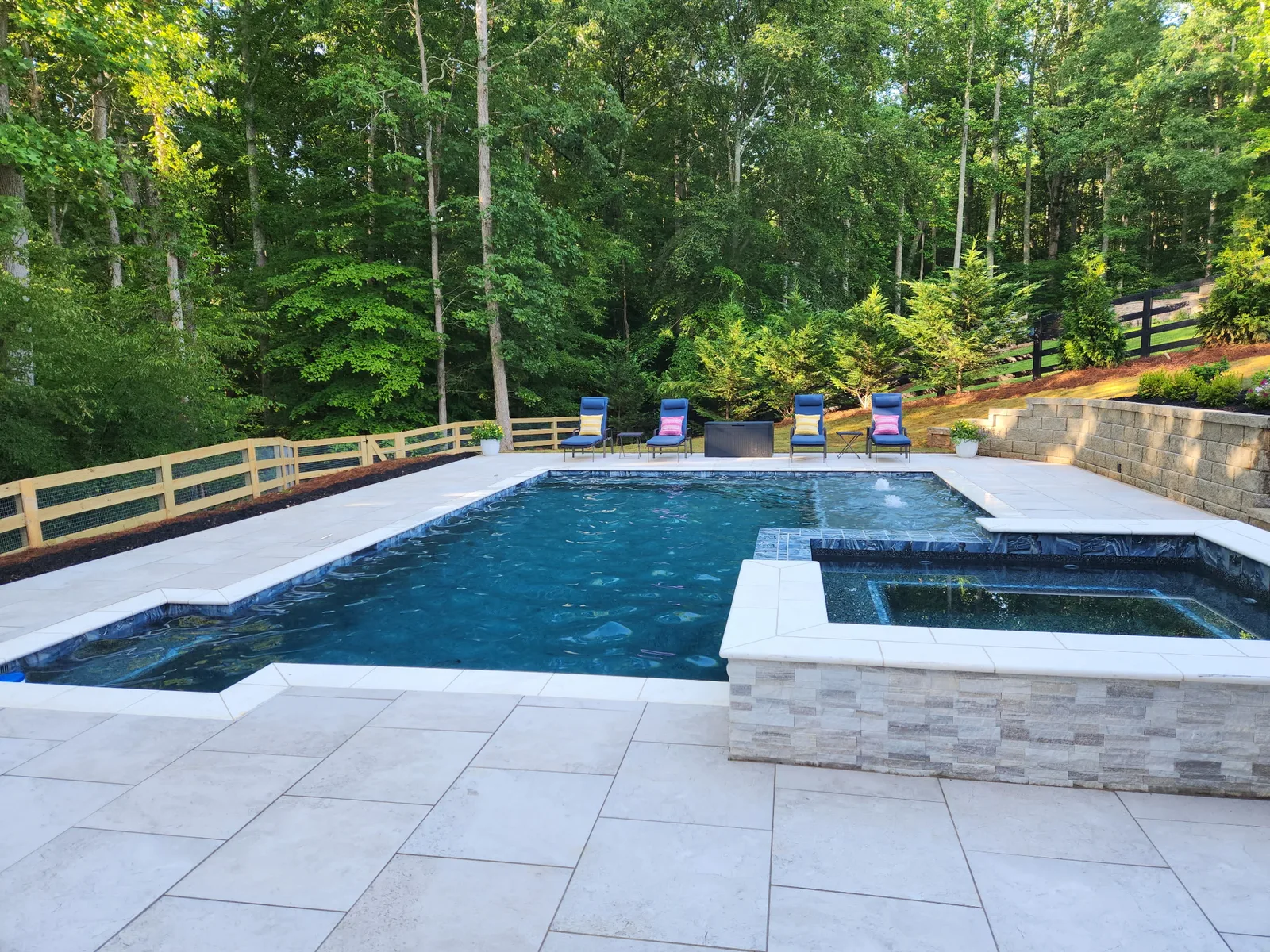 Finished RutherfordMade custom pool with a broad tanning ledge and landscaped patio