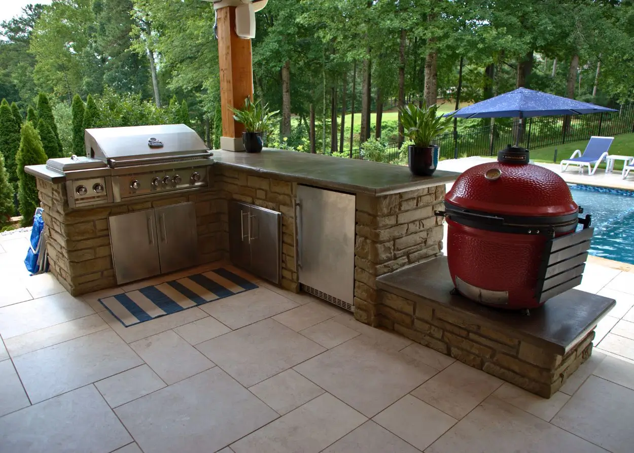 Acworth RutherfordMade outdoor kitchen with built-in grill, stone cabinet, and pool view