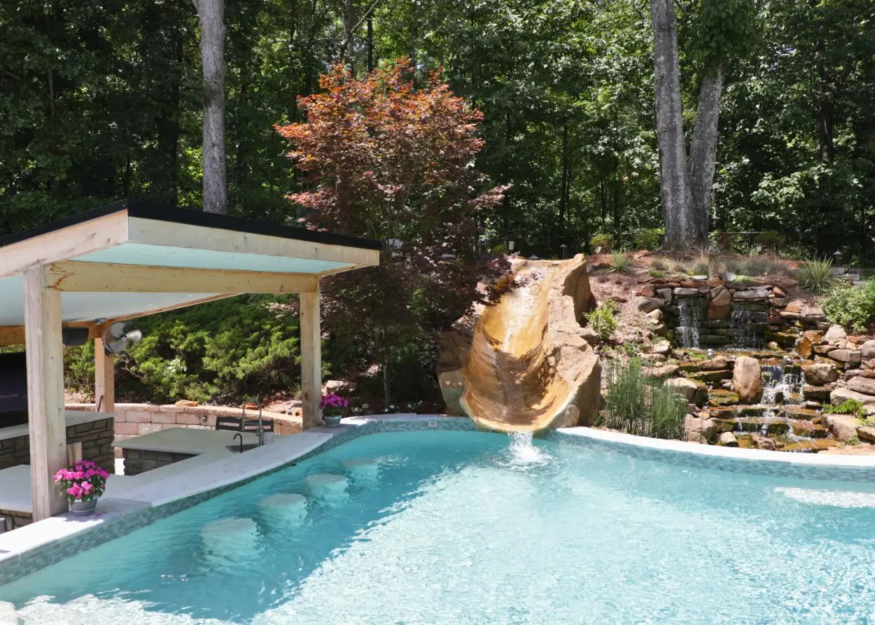 RutherfordMade pool with rock slide, waterfall, patio, and landscape stonework